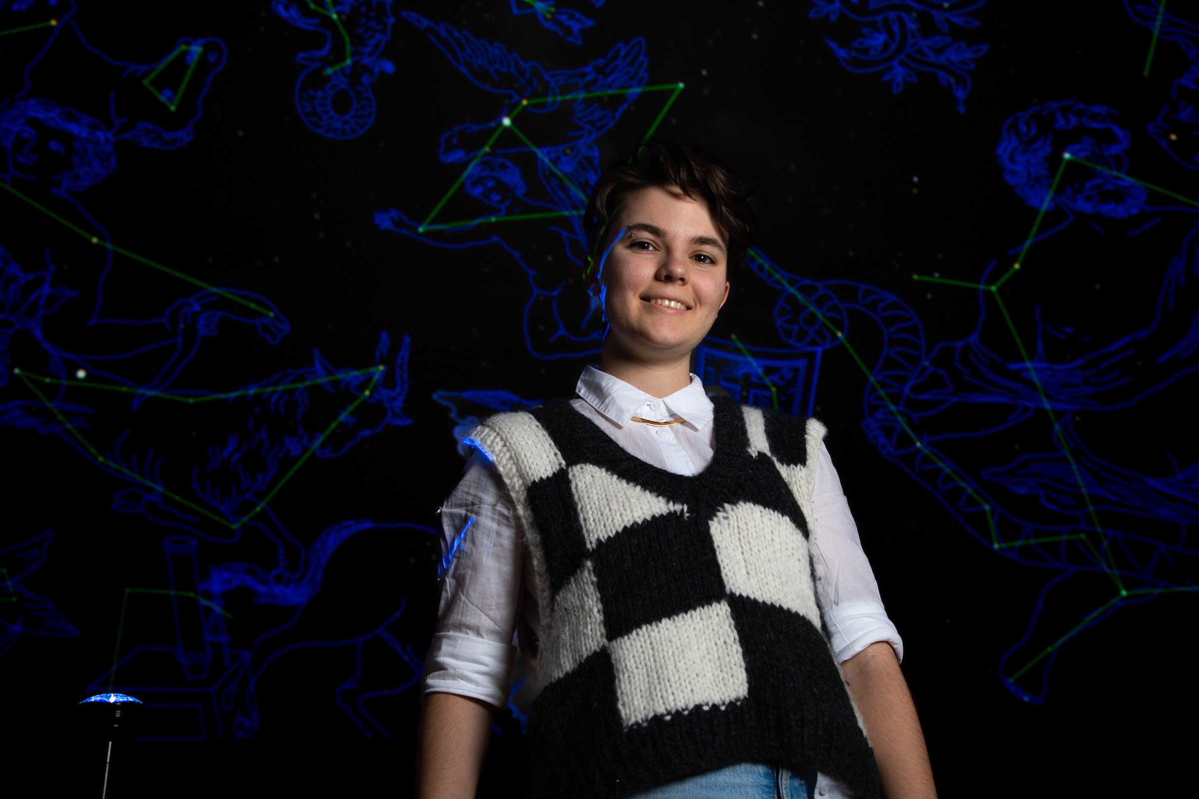 A University of Montana astronomy student posing in UM's planetarium in the Payne Family Native American Center.