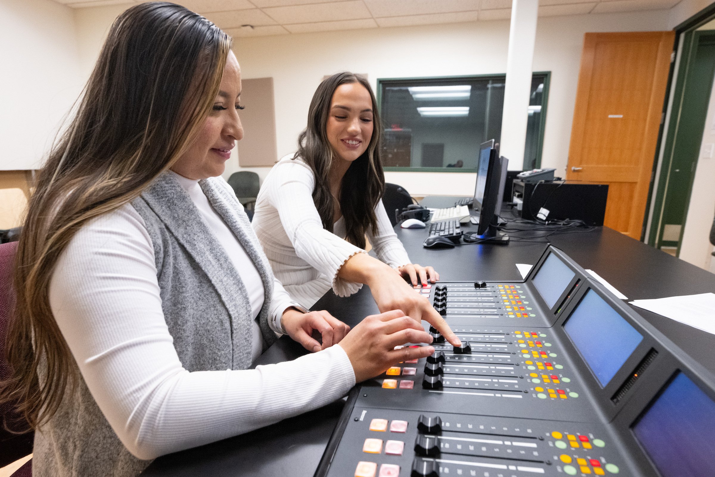 Students learn to use a sound mixer for a podcast training session.