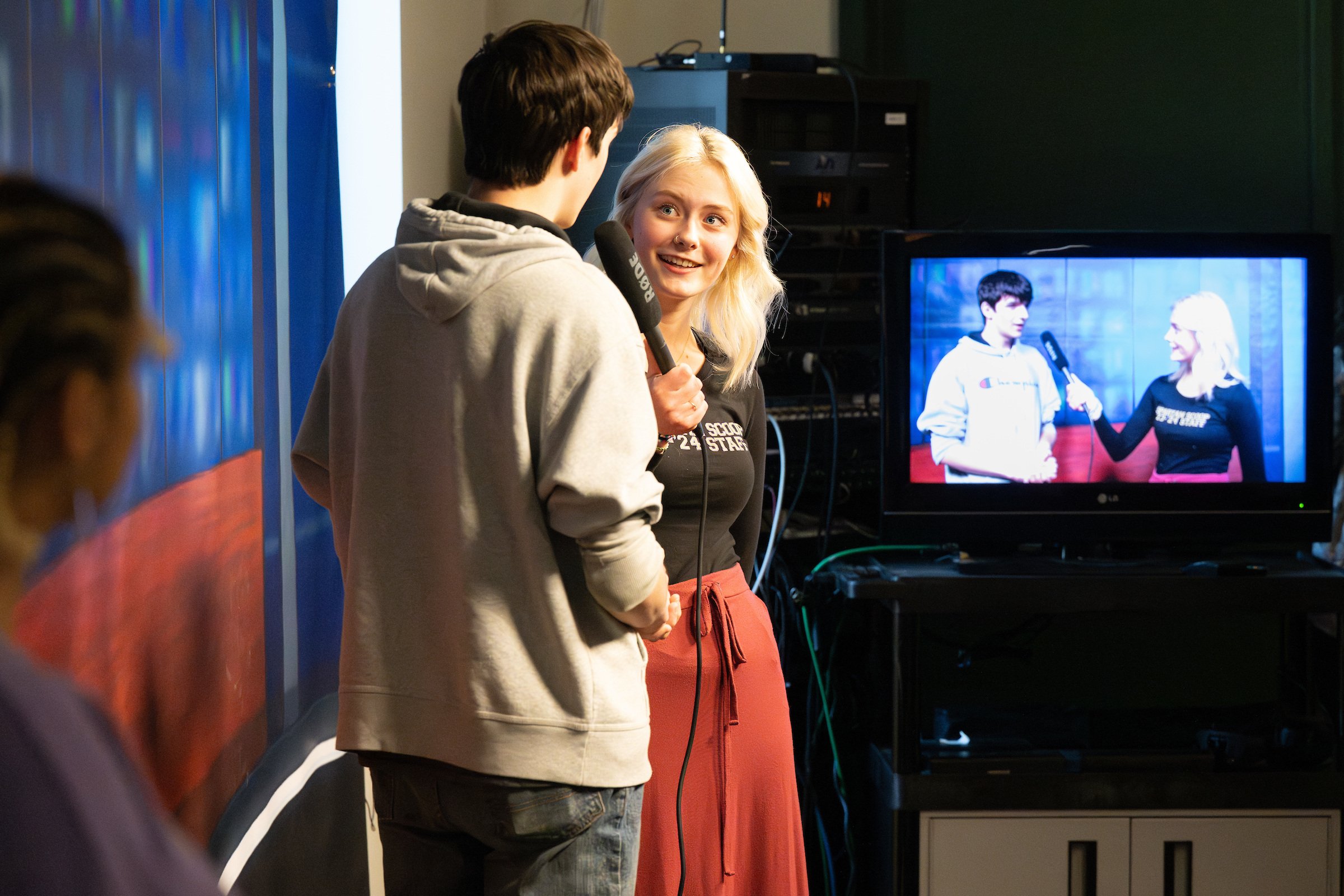 A student interviews another on camera as part of journalism training modules.
