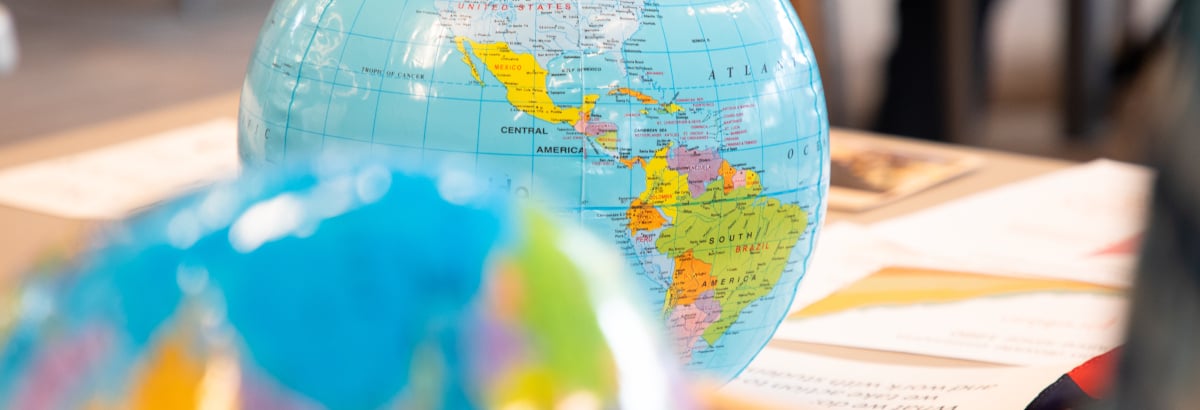 An inflatable globe on a table with other papers and information.